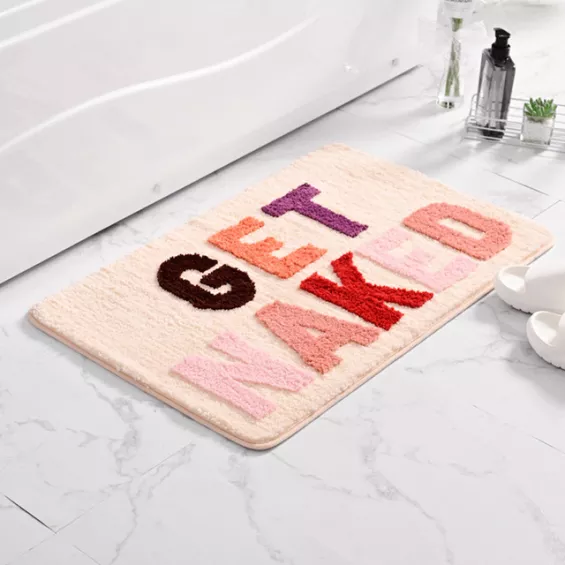 Tapis de salle de bain rose adorable avec des lettres multicolores « get naked »